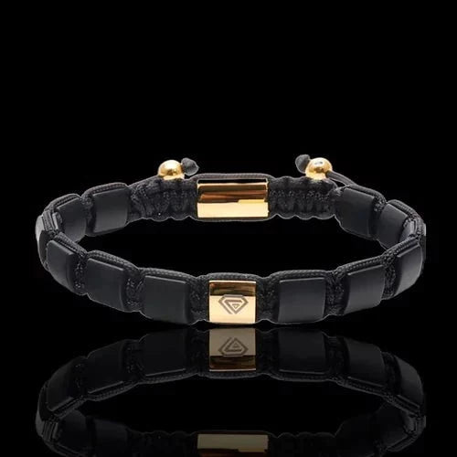 BRACELET  WITH BLACK ONYX AND GOLD CHARM.